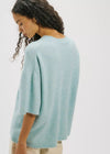 Woman wearing a light blue sweater against a white background