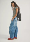 Woman wearing a striped shirt, leather jacket, and blue jeans on a white background