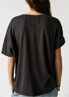 Person wearing a black oversized t-shirt on a plain background