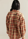 Person wearing a plaid shirt with a neutral background