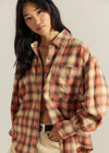 Woman wearing a plaid shirt with a neutral background