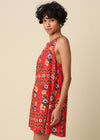 Woman wearing a red floral dress against a beige background