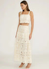 Woman wearing a white lace outfit on a plain background