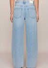 Light blue jeans worn by a person on a beige background