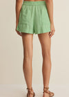 Person wearing green shorts on a beige background