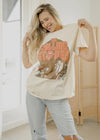 Woman holding a tote bag with Rolling Stones design in a room.