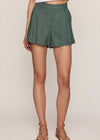 Person wearing green shorts on a plain background