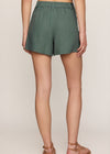 Person wearing green shorts on a beige background