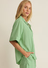 Woman wearing a light green outfit against a plain background